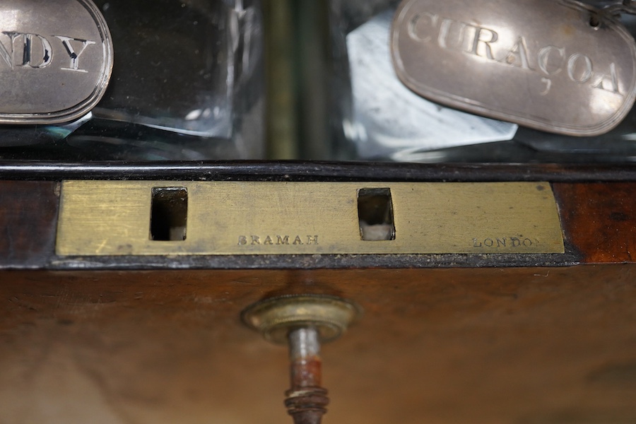 A Victorian burr walnut and brass bound four bottle decanter box, the four faceted square decanters with Victorian silver spirit labels, Bramah lock with key, 26cm high